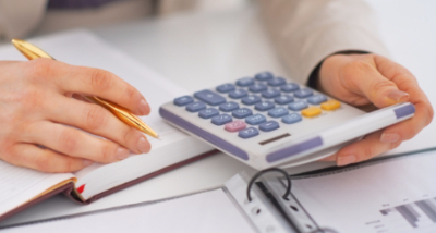 woman working with calculator and pad of paper and pencil